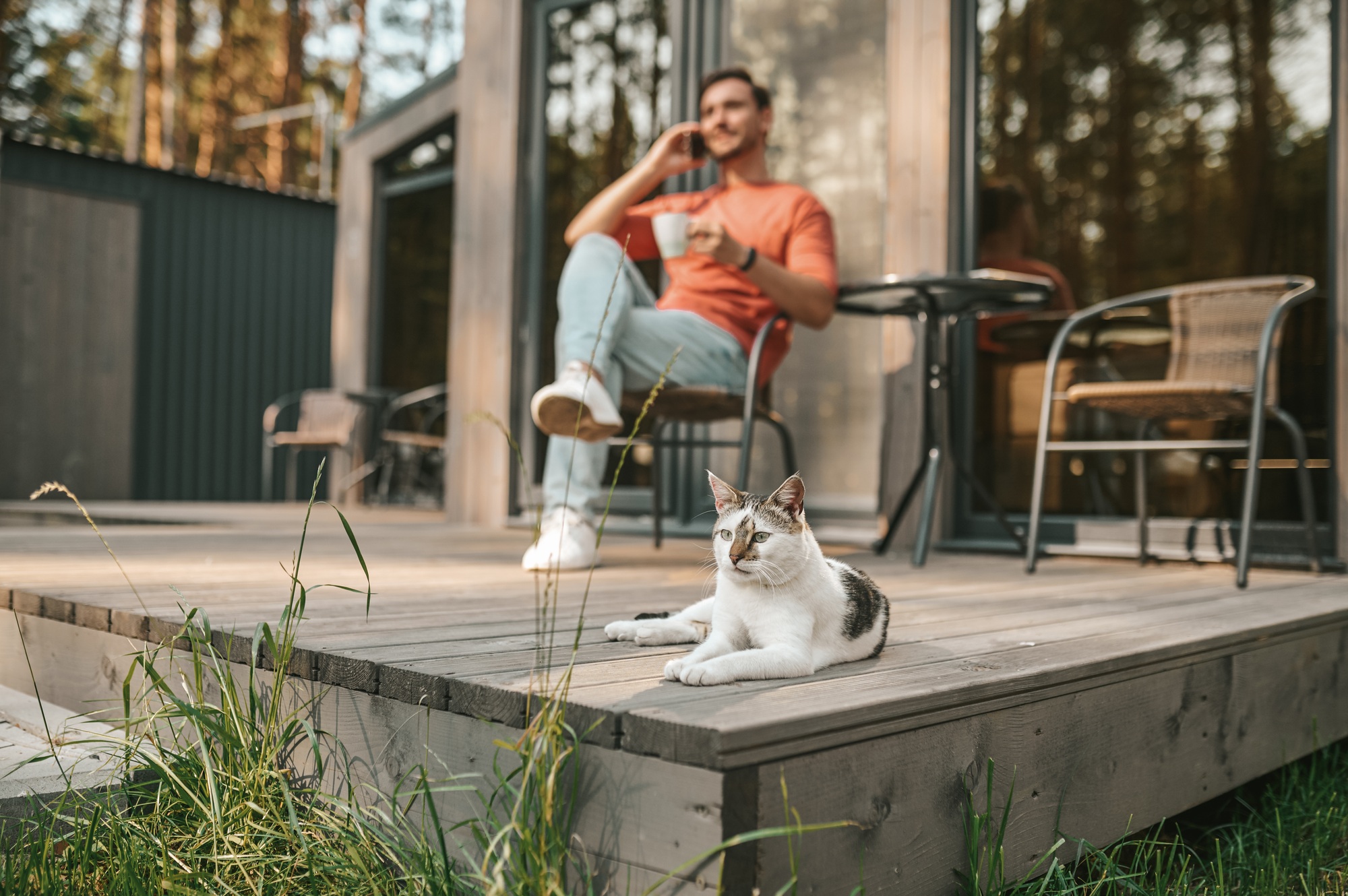 A young man sitting outside and talking on the phone